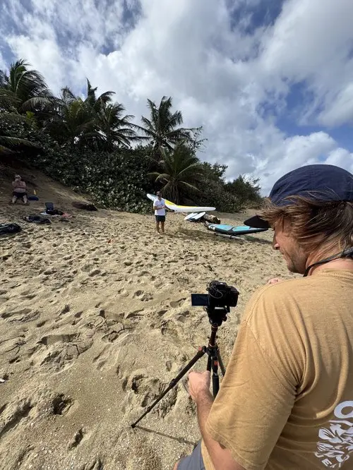 12 месяцев Кайтсерфинг Пуэрто-Рико: исцеление и ветер 2 Видеооператор снимает райдера Cabrinha с досками для серфинга и вингфойлом на тропическом пляже